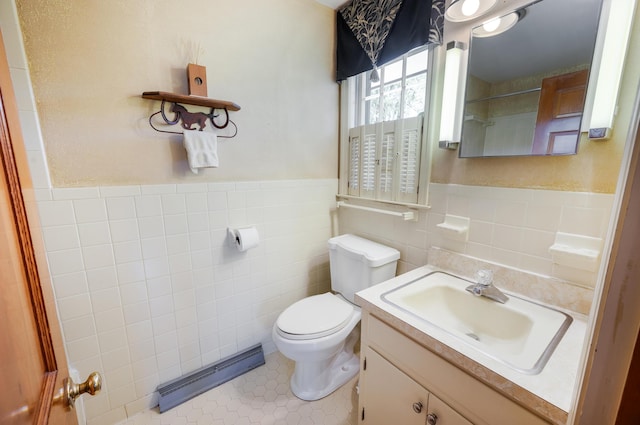 bathroom with tile walls, wainscoting, vanity, tile patterned floors, and toilet