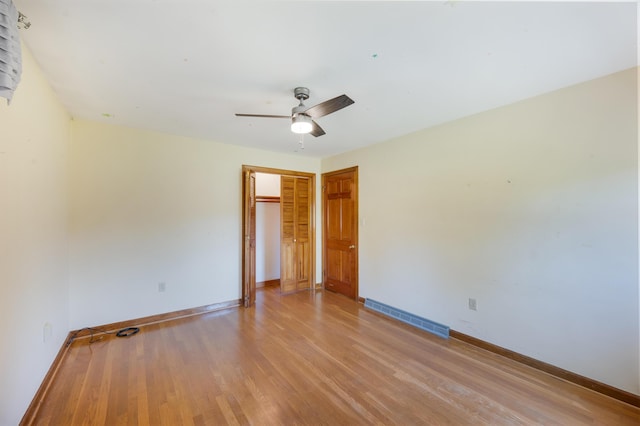 unfurnished room featuring baseboards, a ceiling fan, light wood finished floors, and visible vents