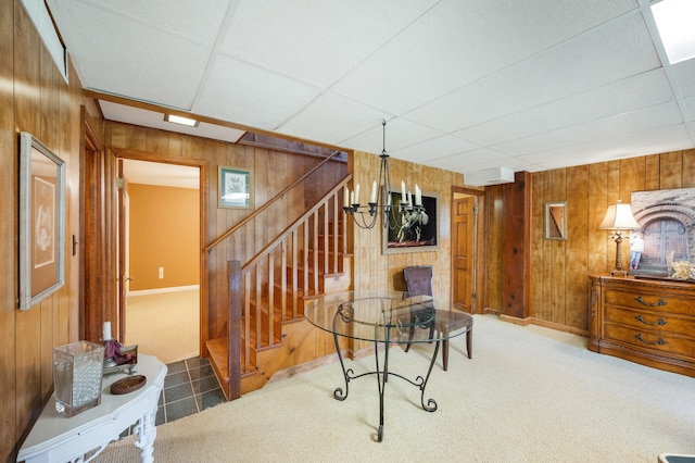 interior space with wooden walls, baseboards, a drop ceiling, and stairway