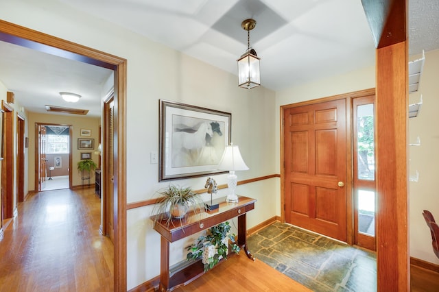 foyer entrance featuring baseboards and wood finished floors