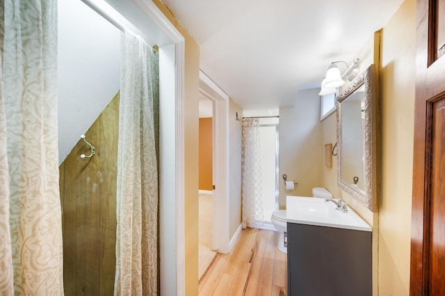 bathroom with vanity, wood finished floors, and toilet