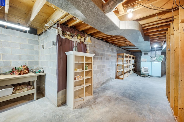 unfinished basement with heating unit and concrete block wall