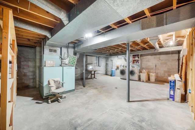 unfinished below grade area with heating unit, visible vents, and washer and clothes dryer
