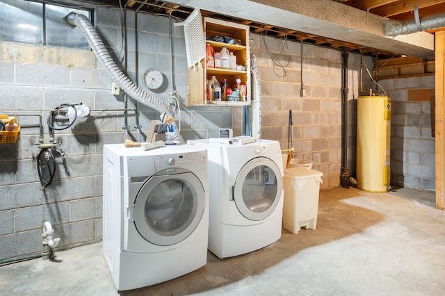 washroom featuring water heater, laundry area, and washing machine and dryer