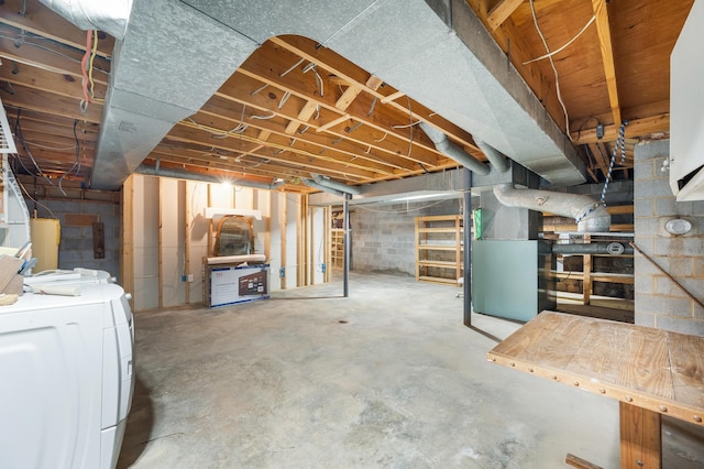 unfinished basement featuring heating unit and washing machine and dryer