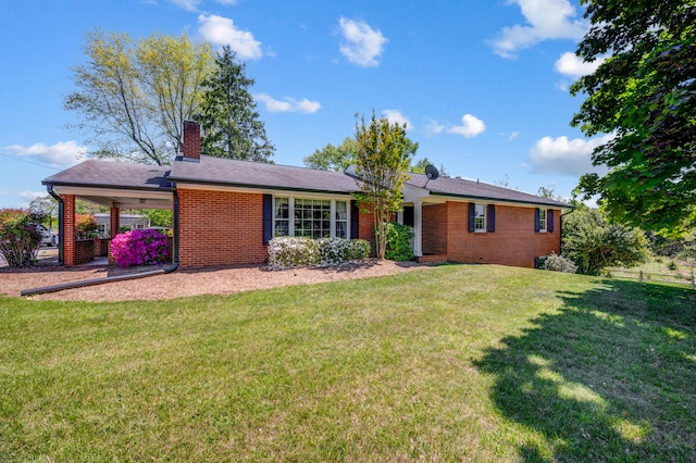 view of front of home featuring brick siding, a carport, a chimney, and a front lawn