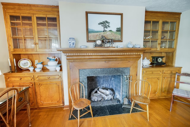 living area with a fireplace with flush hearth and wood finished floors
