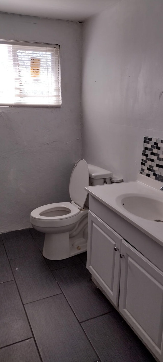 half bath featuring vanity and toilet