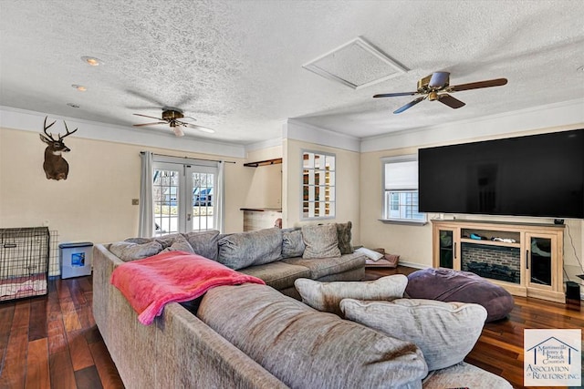 living room featuring a textured ceiling, ceiling fan, and ornamental molding