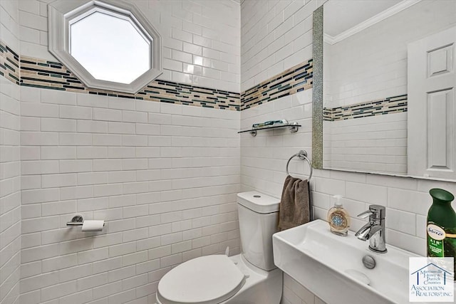 bathroom with ornamental molding, toilet, tile walls, a sink, and backsplash