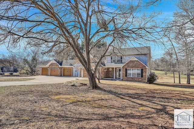 traditional-style home featuring an attached garage, driveway, and brick siding