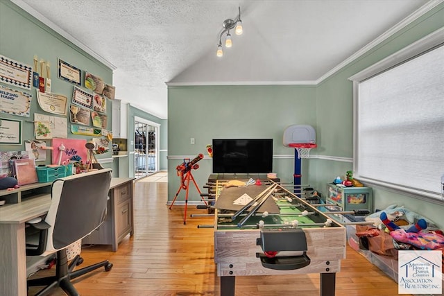 home office with a textured ceiling, vaulted ceiling, ornamental molding, and light wood finished floors