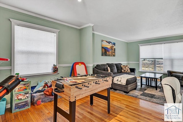 playroom featuring crown molding, plenty of natural light, and hardwood / wood-style flooring