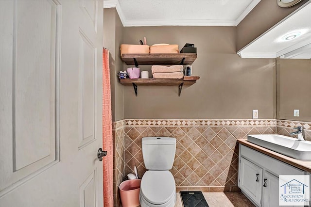 bathroom with crown molding, toilet, tile walls, and vanity