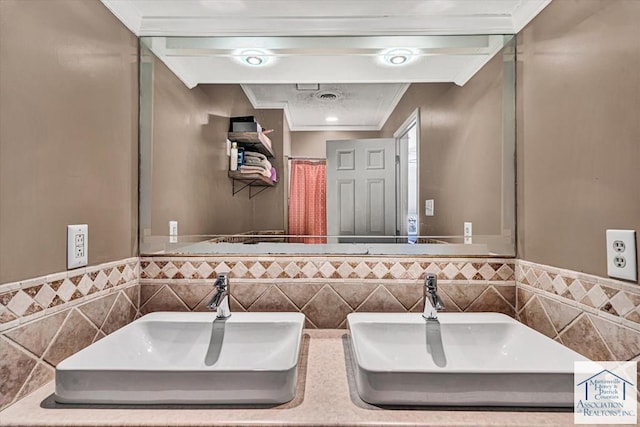 bathroom featuring a sink, tile walls, and ornamental molding