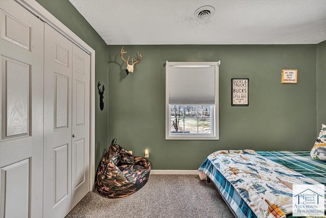 bedroom featuring baseboards, visible vents, carpet, and a closet