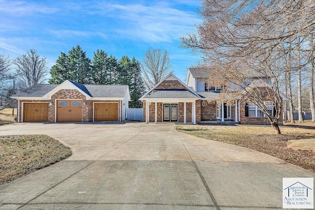 craftsman-style home with concrete driveway, fence, french doors, and a garage