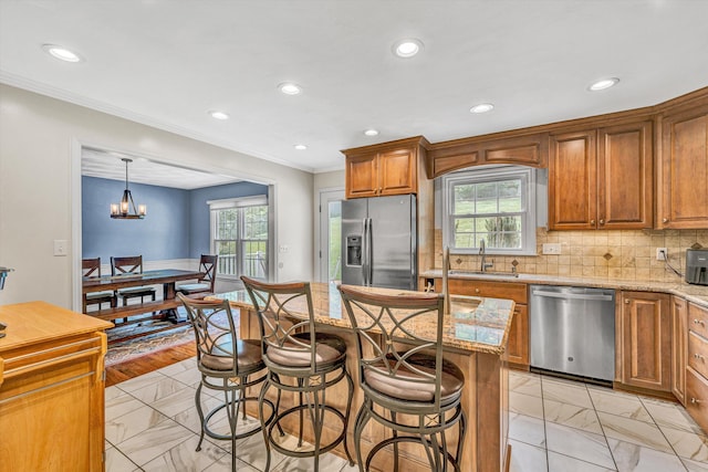 kitchen with stainless steel appliances, light marble finish floors, a kitchen breakfast bar, light stone countertops, and recessed lighting