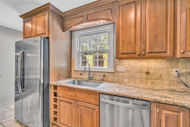 kitchen featuring stainless steel appliances, a sink, decorative backsplash, brown cabinetry, and ornamental molding