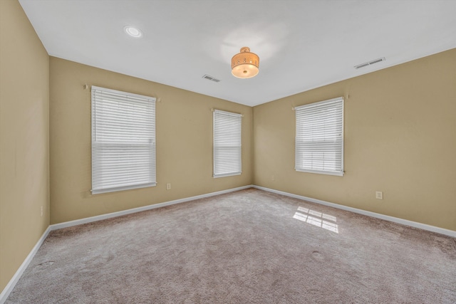 empty room featuring carpet and baseboards
