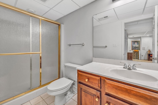bathroom featuring tile patterned floors, a drop ceiling, vanity, a stall shower, and toilet