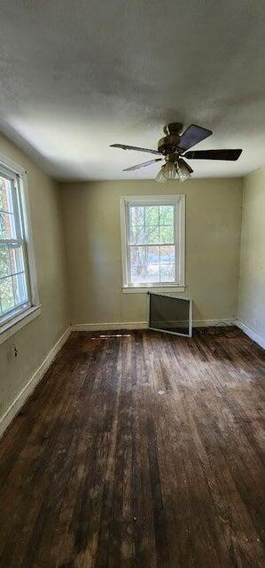 unfurnished room featuring baseboards, ceiling fan, a healthy amount of sunlight, and wood finished floors