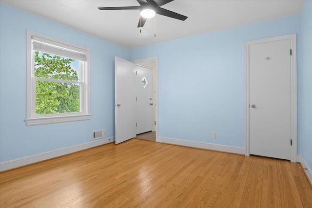 unfurnished bedroom with visible vents, a ceiling fan, baseboards, and wood finished floors