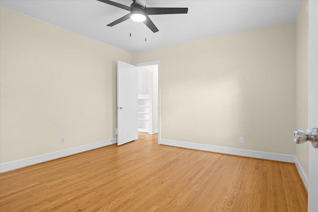 spare room with baseboards, ceiling fan, and light wood-type flooring