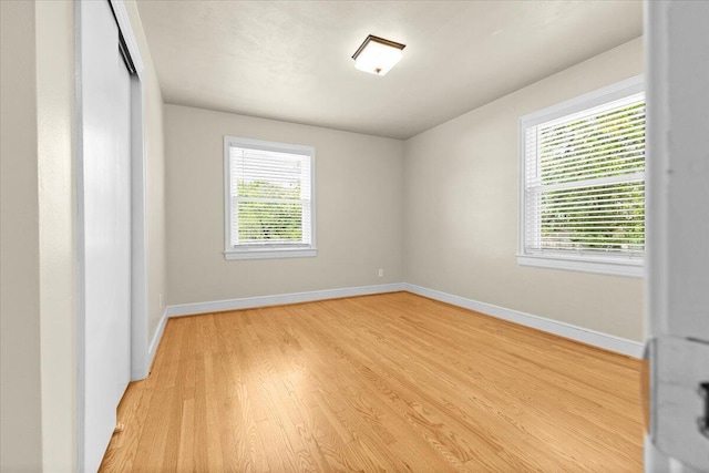 empty room with baseboards and light wood-style flooring