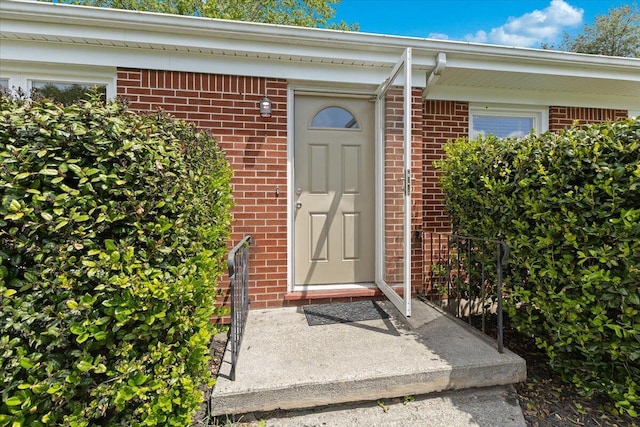 view of exterior entry with brick siding