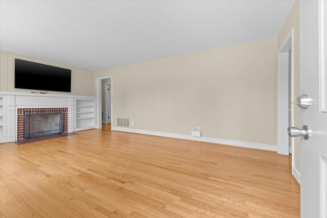 2738 Thorndale St SW, Roanoke, VA 24015 - unfurnished living room with light wood-style flooring, baseboards, and a brick fireplace