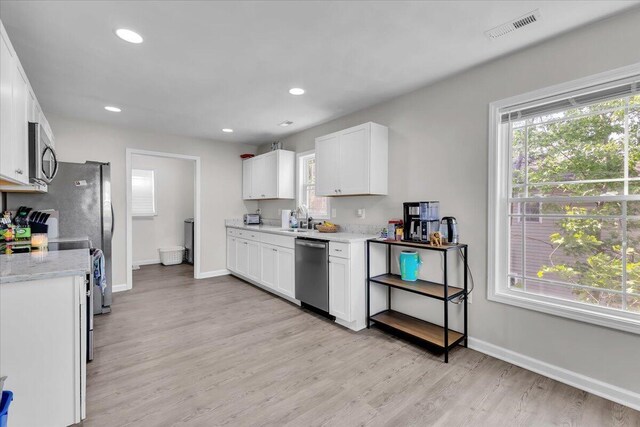 1624 24th St NE, Roanoke, VA 24012 - kitchen with white cabinets, baseboards, appliances with stainless steel finishes, and light wood finished floors