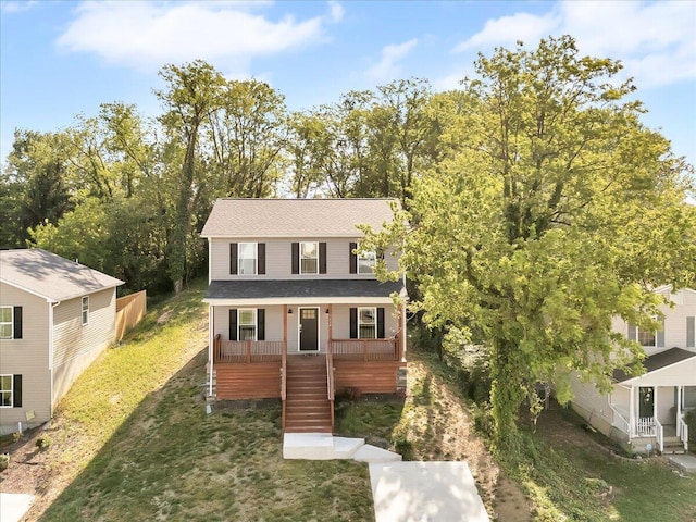 view of front of home with stairway, roof with shingles, covered porch, and a front yard