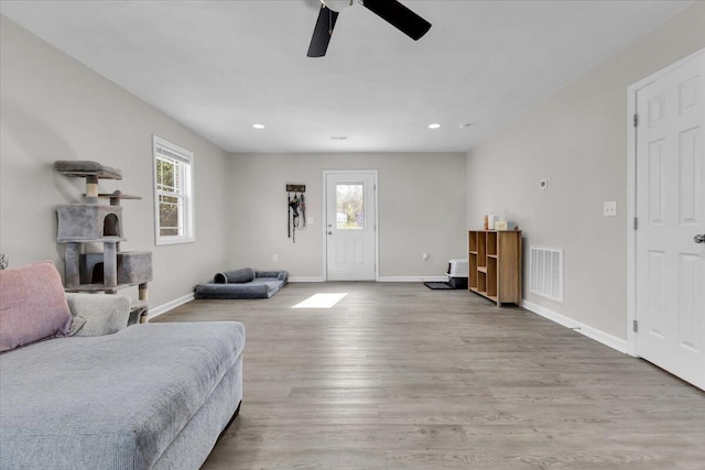 bedroom featuring baseboards, visible vents, multiple windows, and wood finished floors
