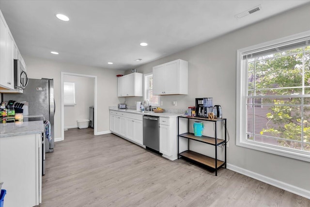 kitchen featuring baseboards, appliances with stainless steel finishes, a sink, and visible vents