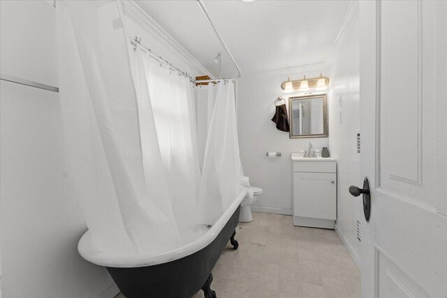 full bath featuring vanity, ornamental molding, baseboards, and toilet