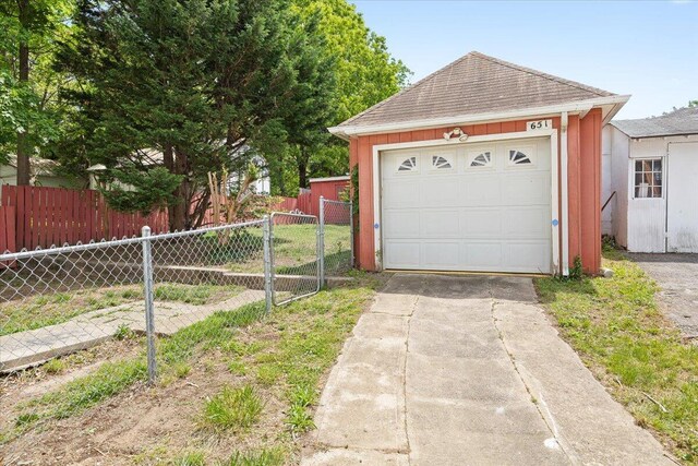 garage with fence and driveway