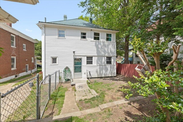back of property with a fenced backyard and a chimney