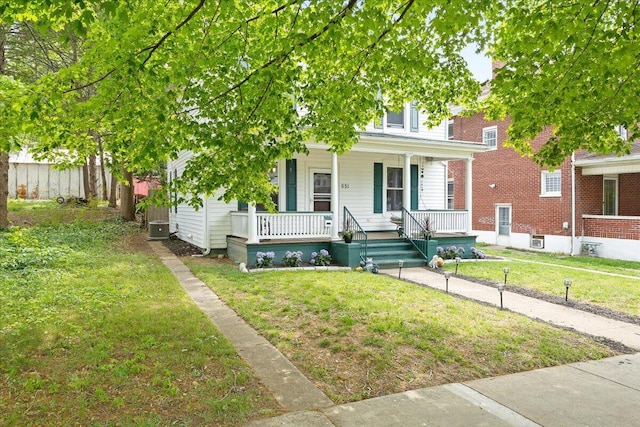 view of front facade with a porch, a front lawn, and cooling unit