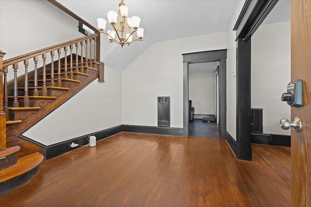 interior space featuring hardwood / wood-style flooring, baseboards, stairs, and a notable chandelier