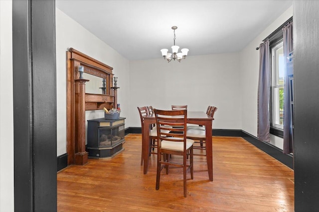 dining room with wood finished floors and a chandelier