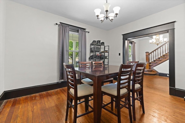 dining room featuring a notable chandelier, hardwood / wood-style flooring, and stairway