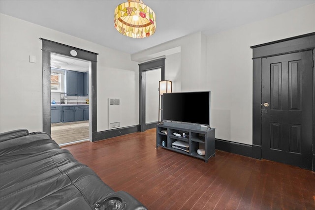 living area with baseboards and wood finished floors