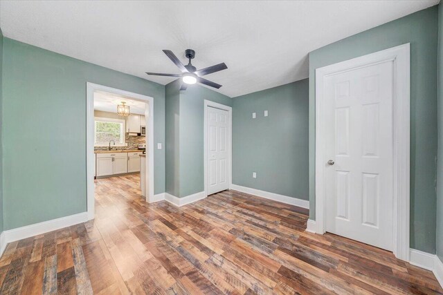 215 Heatherwood Dr, Boones Mill, VA 24065 - unfurnished bedroom with baseboards, a sink, ceiling fan with notable chandelier, and wood finished floors