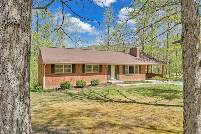 ranch-style home featuring brick siding, a front lawn, a chimney, and a porch