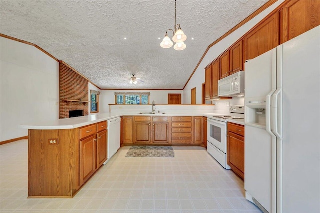 kitchen featuring crown molding, a sink, white appliances, a textured ceiling, and a peninsula