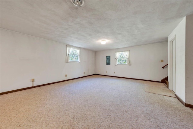 carpeted spare room with baseboards, plenty of natural light, stairs, and a textured ceiling