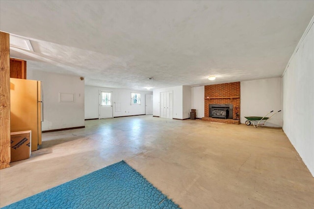 basement featuring freestanding refrigerator and a brick fireplace