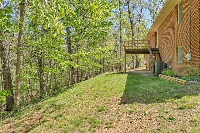 view of yard with stairs, central AC unit, and a deck
