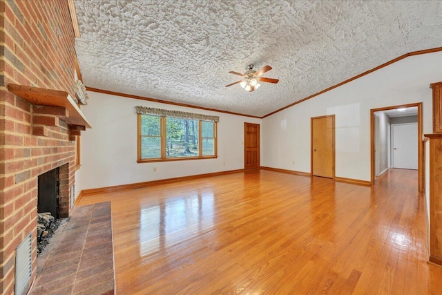 unfurnished living room with a fireplace, ceiling fan, lofted ceiling, and light wood-style floors